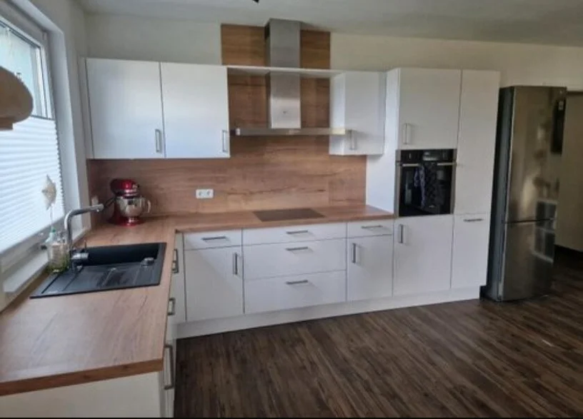 Weiße Küche mit Holzrückwand und Holzarbeitsplatte in Wilhelmshaven