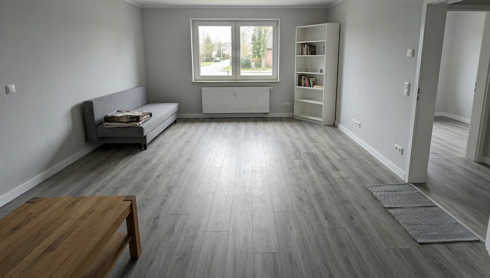 Weitere Referenzansicht des verlegten Vinylbodens im Wohnraum in Wilhelmshaven. Großer Wohnraum mit fertig verlegtem Vinylboden in Wilhelmshaven